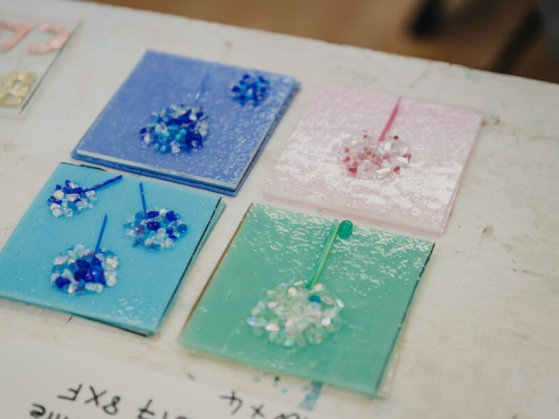 Some fused glass square coasters with flower images in blue, white, pink and green